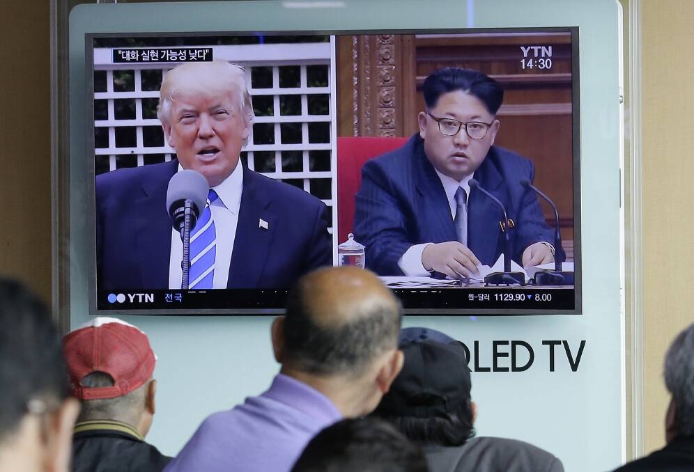 US President Donald Trump and North Korean President Kim Jong-un trading verbal firepower and fury on the news screen at a South Korean railway station .