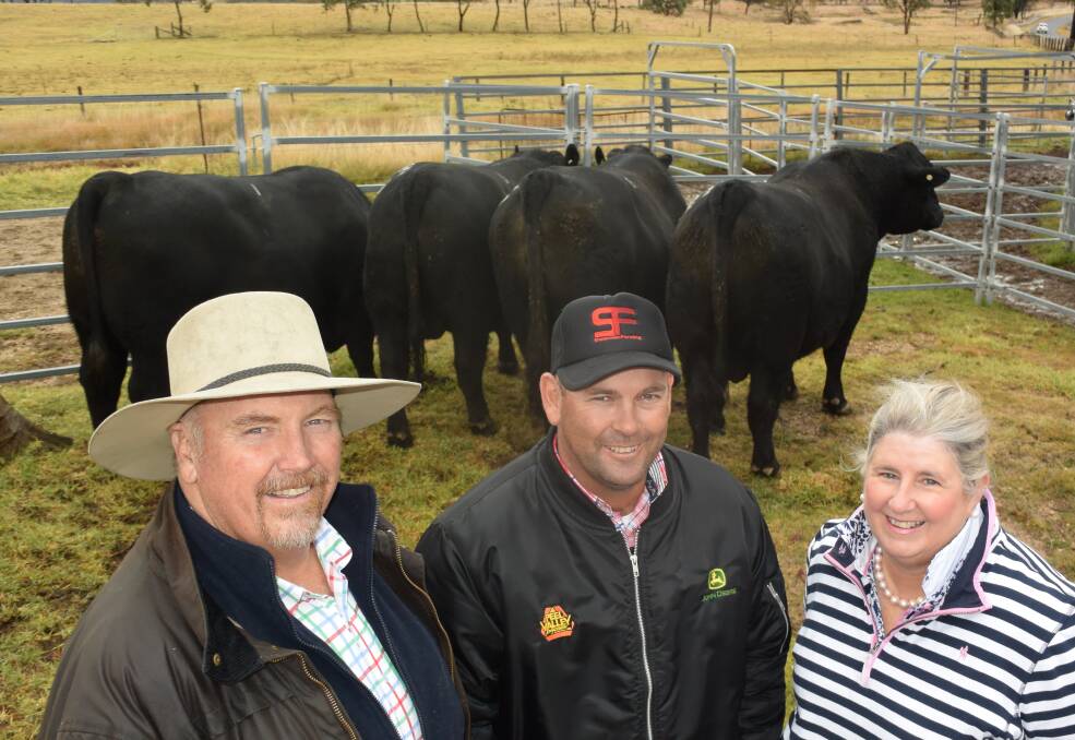 The Alumy advantage: Top price bidder and volume buyer Elliott McKinnon, ‘Dales’ Merriwa, centre, with Alumy Creek Angus owners Colin Keevers and Lisa Martin at last years on-property bull sale at Tenterfield.