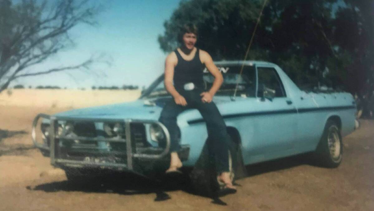 A photograph of Dave Wyllie as a young man perched on his Holden ute in outback Queensland. Picture: Supplied