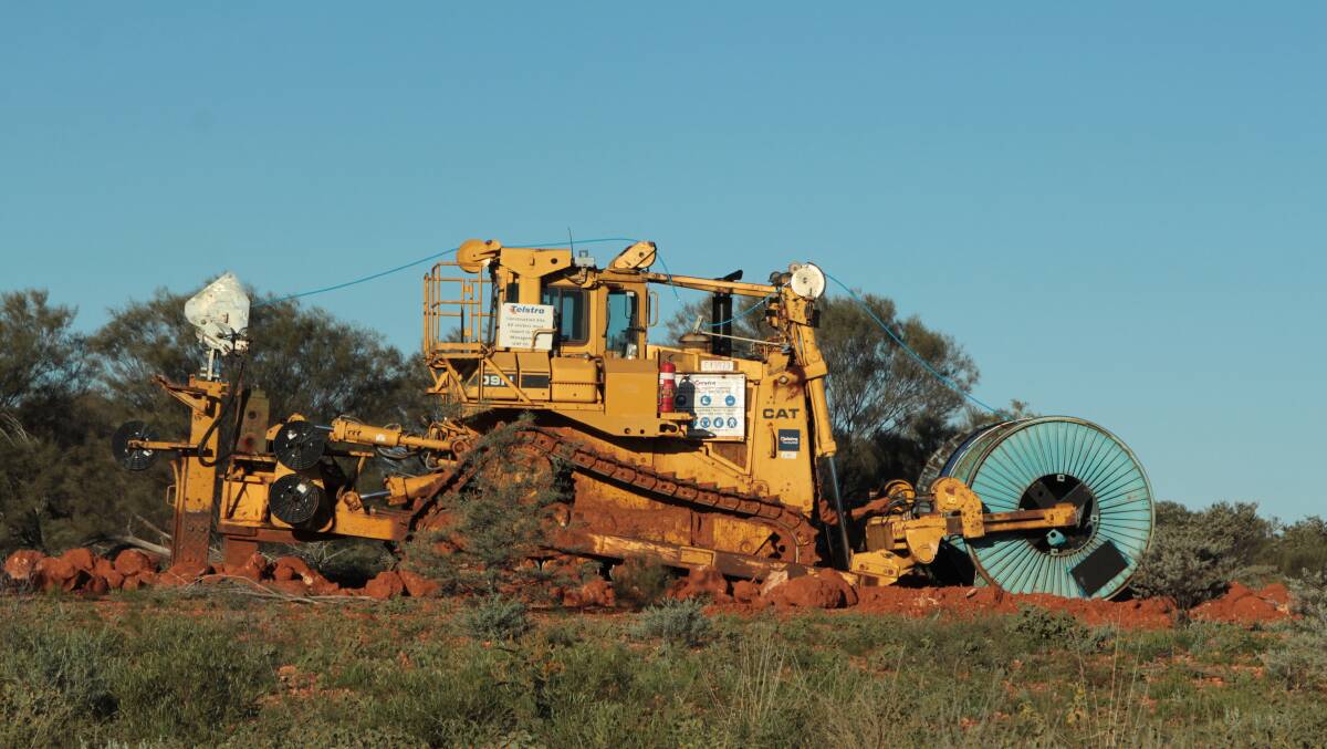 Telstra's cable-laying machine at work near Windorah last week. It often had challenging terrain to negotiate.