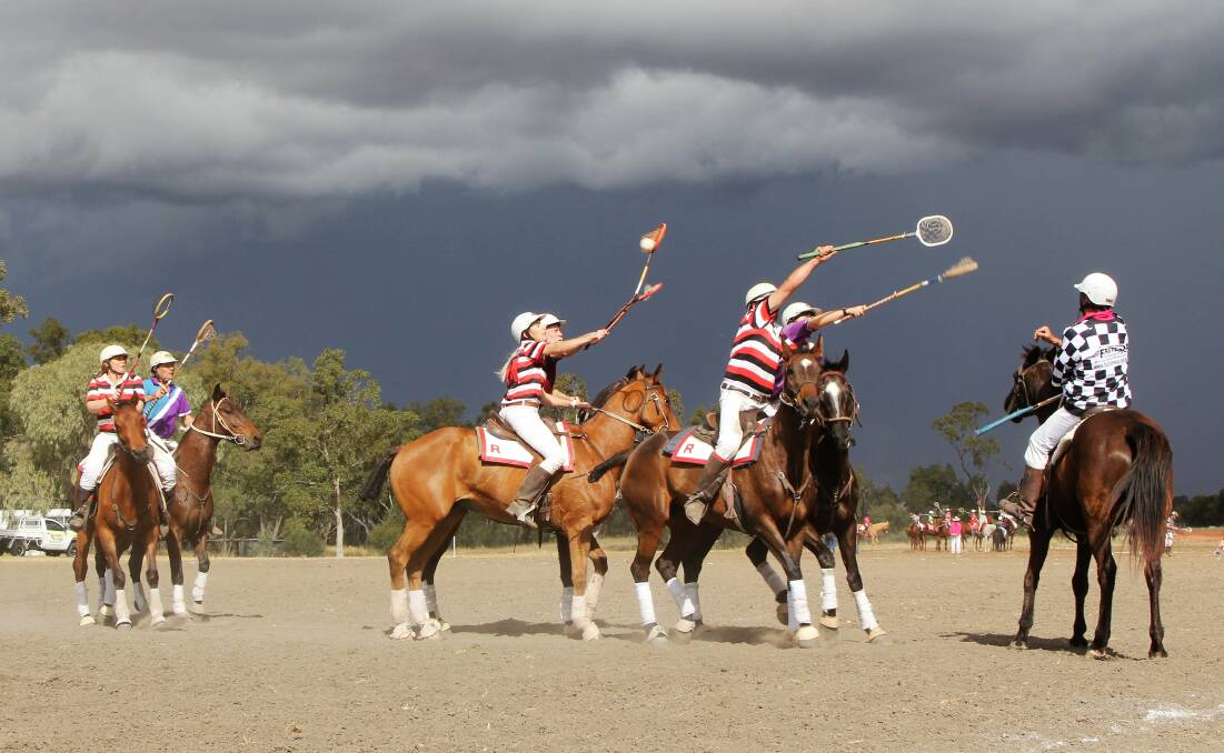 Roma and Longreach polocrosse teams playing in front of a menacing storm front.