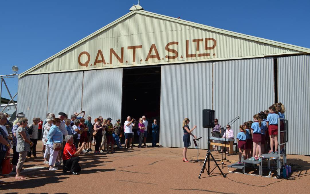 Some of the crowd gathered for the historic occasion at the Qantas hangar, including a Longreach State School singing group.