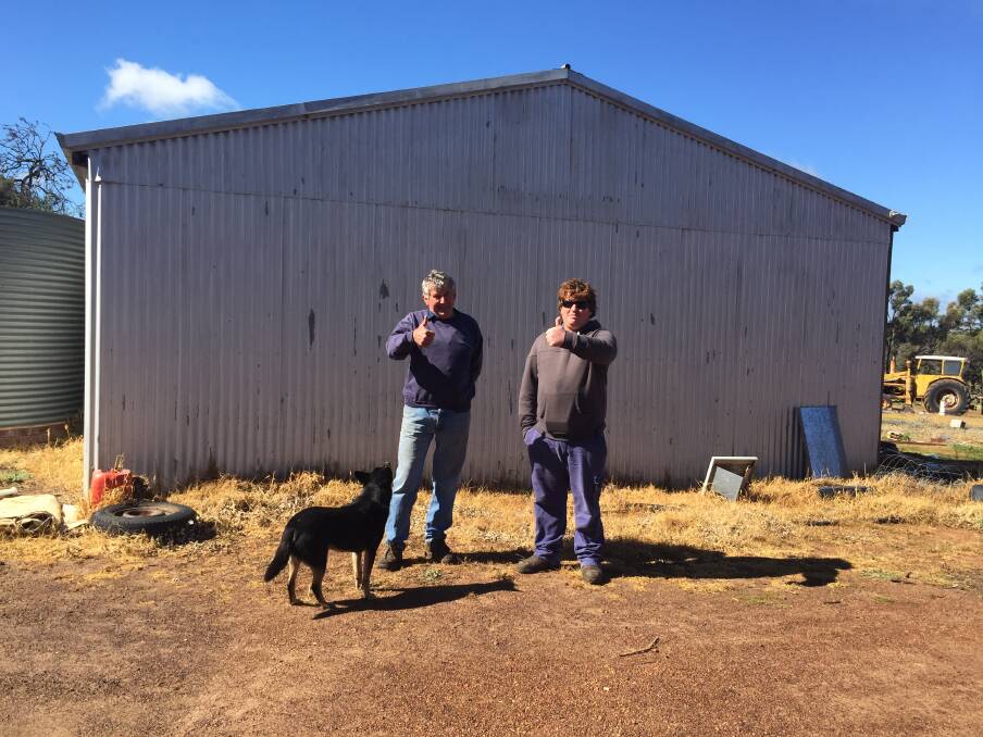 Bruce and Simon Dixon standing where straw bales once blocked a car's passage which helped save their farming business.