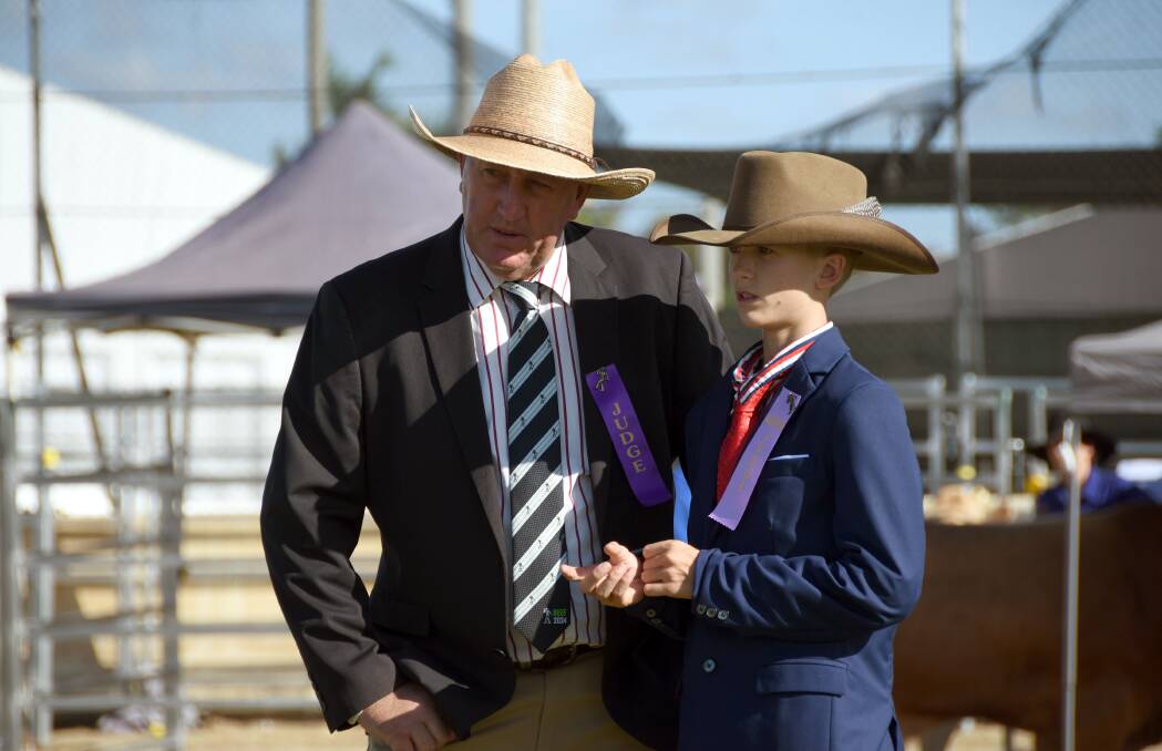 Judge Scott Hann, Bellata, NSW confers with 2-year-old associate judge Callum McUtchen, Jandowae at the Blonde d'Aquitaine competition. Picture by Ashley Walmsley