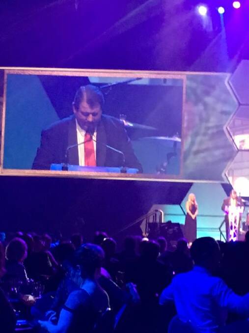 Victoria Hotel publican, and Hotelier of the Year,  John Klein on the big screen at the QHA awards in Brisbane.