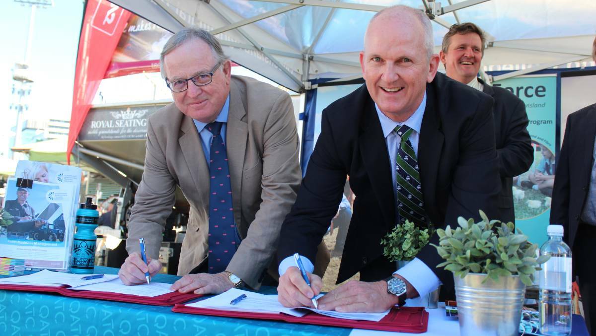 QATC chair Hugh Rose and then-AgForce chief executive Charles Burke sign a training partnership in 2017.