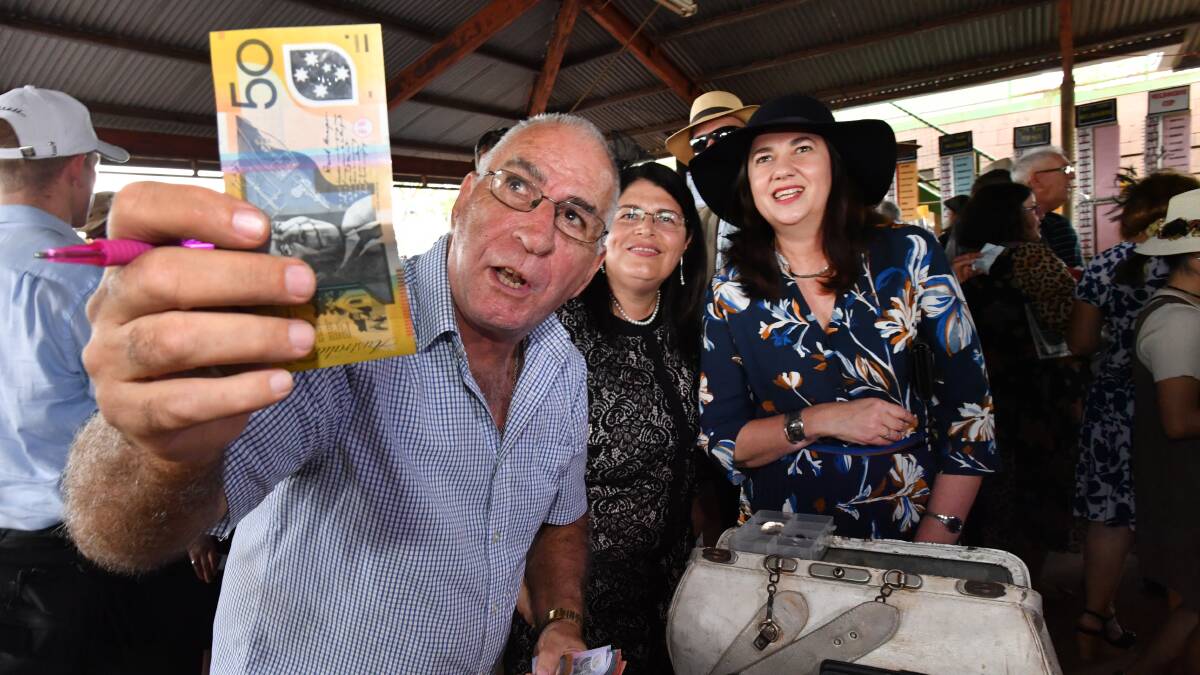 Racing Minister Grace Grace and Premier Annastacia Palasczcuk place a bet with bookmaker Trevor Byrnes at the Kumbia Race Club. Photo: Darren England/AAP