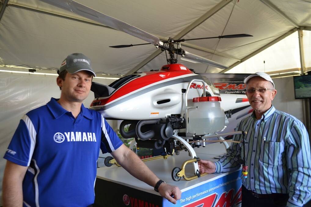 Yamaha sales manager Mike Johnson, Wetherill Park, NSW, points out the features of the Yamaha RMAX unmanned helicopter to Sunshine Coast-based project manager Peter Robinson at Heritage Bank Ag Show, Toowoomba.
