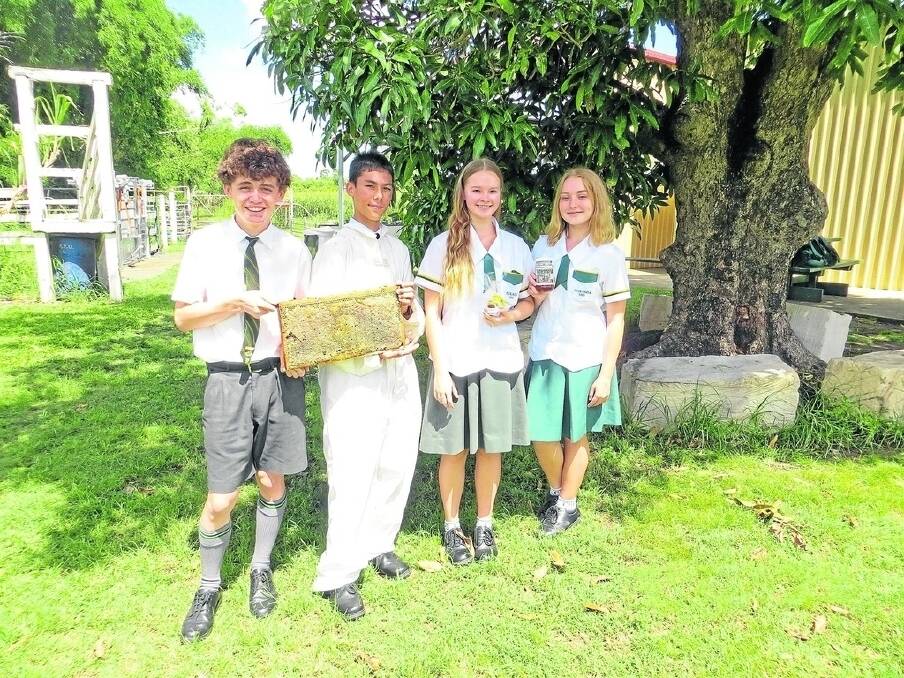 Club members Mitchell May, Matthew Guevarra-Adams, Imogene Davidson and Anna Heckenberg proudly display their product and a frame of Corinda honey.