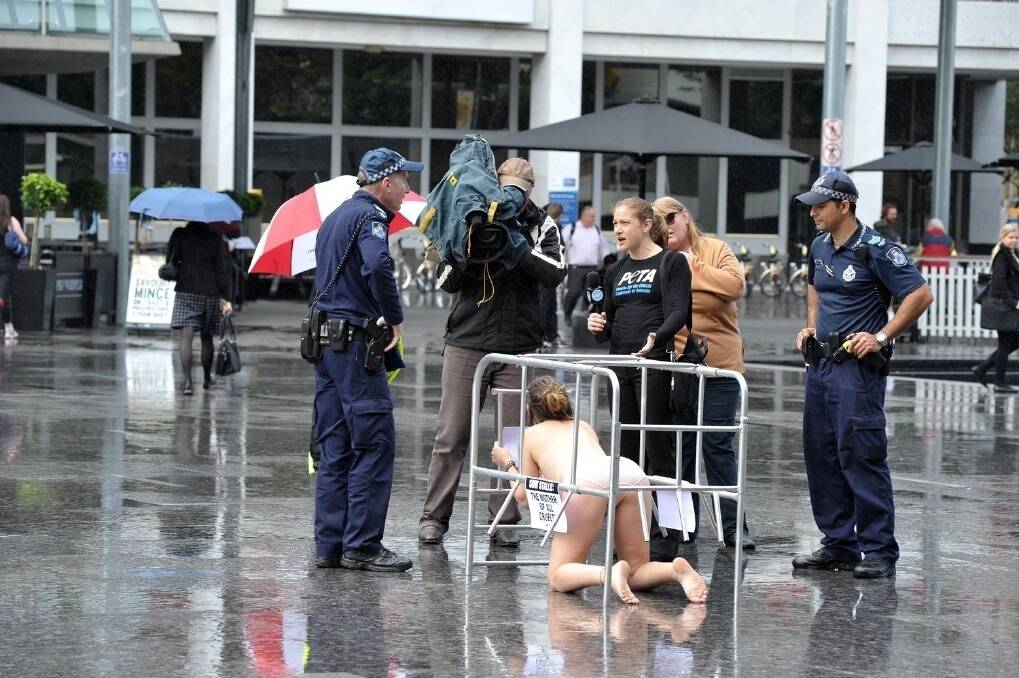 OUT IN THE COLD: Near-naked PETA protestor draws attention of police in Brisbane's King George Square yesterday. <i>Picture: RODNEY GREEN</i>