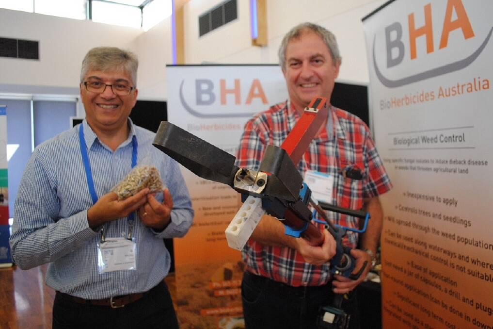 Associate Professor Victor Galea from the University of Queensland with the Di-Bak Pakensonia capsules and Dr Ken Goulter from BioHerbicides Australia with the applicator at the Reef, Range and Red Dust conference.