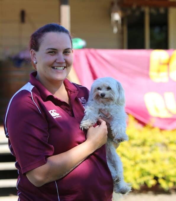 Corey's sister Jenna Oates with the family dog. The whole house is decorated to cheer on the maroons - despite being many kilometers from the nearest neighbours. 