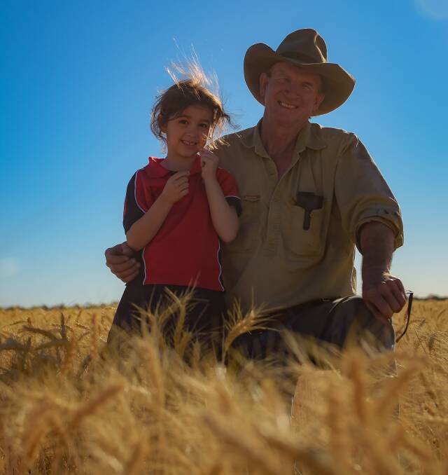 Ross Phillis, Lochmead, Gindie, with his granddaughter Georgina, in this year's wheat which is being harvested now. Photo - Kelly Butterworth.