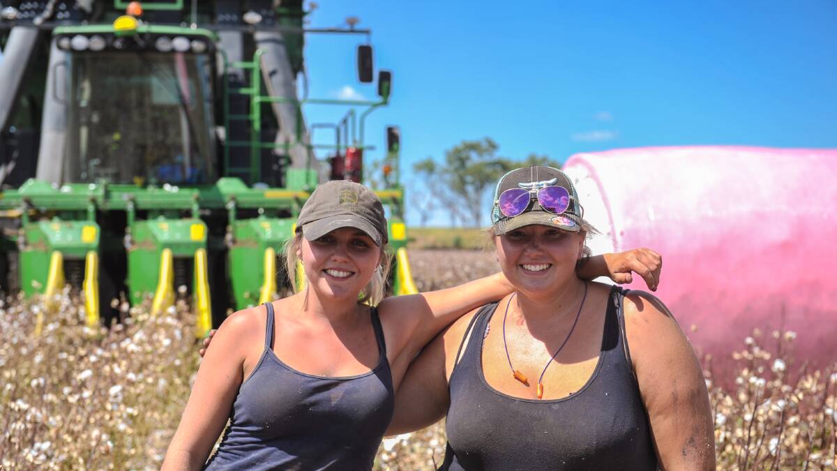 Contract pickers, cousins Molly Keeley, 20, and Chelsea Klys, 18, stand before the picker and a pink bale at Cameron and Tracey Geddes' farm west of Emerald. Photos - Kelly Butterworth. 