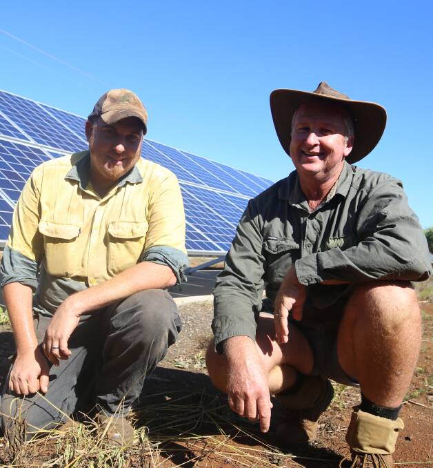 INNOVATION: Jason Griffin with dad, Kelvin, on the family cane farm in Bundaberg with some of the the newly-installed solar panels. 
