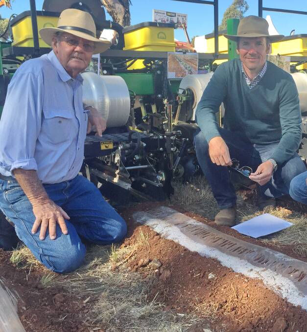 HEAT RETENTION: Robin Krieg, Bostocks, Brookstead, and David McGrath, checking out One Crop's soil heat retention system, on the Norseman stand.  