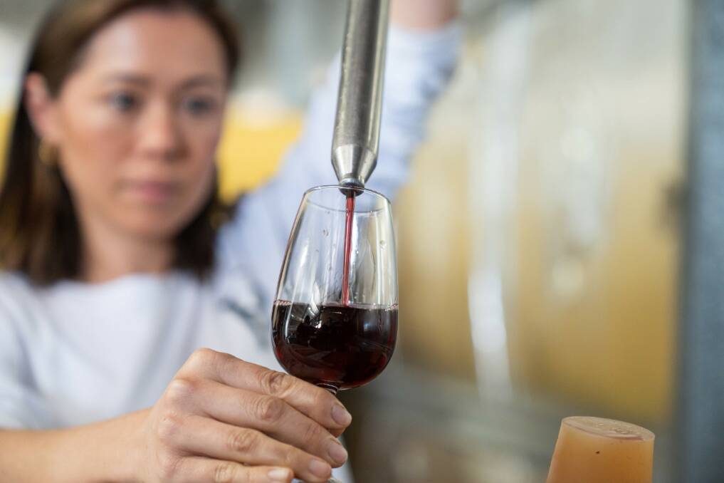 Caitlin Roberts pouring one of their red wines at their Ravenscroft Vineyard. Picture: QRIDA