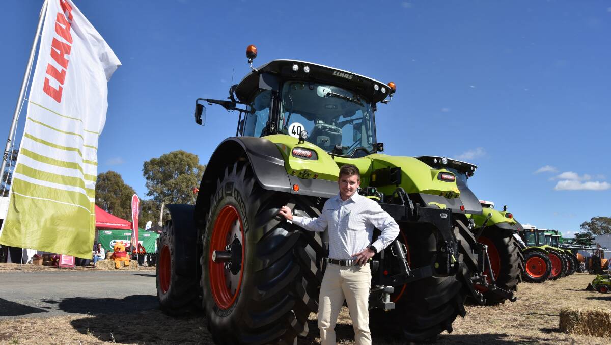 POWER TO THE GROUND: Dylan Mott, sales consultant, Claas Harvest Centre, Dalby, Qld with the new Claas 950 Axion at CRT FarmFest, Toowoomba Qld.
