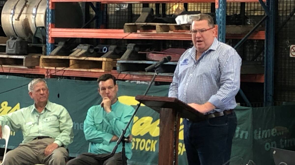 Ross Fraser and Athol Carter, Frasers Livestock Transport, watch as Assistant Minister Scott Buchholz addresses the crowd of over 50.