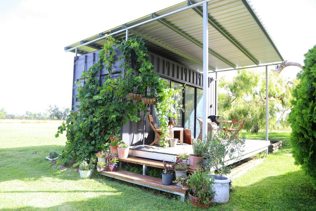 Anna Nicholson's art studio crafted out of a shipping container, with a porch, steps and roof added.