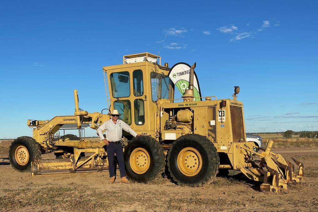 Auctioneer Chris Tomkins and the $101,000 grader sold as part of the sell-off of the Longreach Pastoral College's assets. Picture supplied.