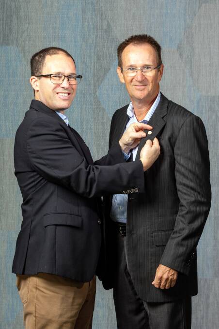 Outgoing RDAQ president Dr RT Lewandowski pins the badge on for incoming president Dr Michael Reinke. Picture supplied.