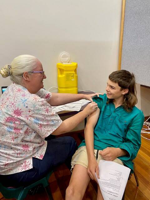 Marshall Baillie, aged 14, pictured being immunised by nurse Breda Lynch, was the first under-16-year-old to be vaccinated in the central west, at a vaccination clinic at Blackall at the end of August. Picture supplied.