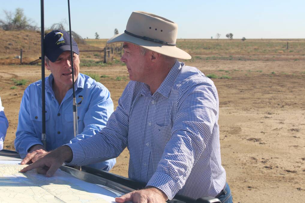 AgForce CEO Mike Guerin and Resources Minister Scott Stewart pore over maps on the open downs country around Ilfracombe. Picture: Vol Norris
