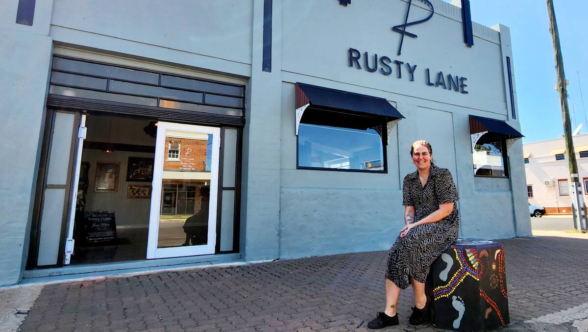 Jane White in front of her printing, design and drive-in coffee business, seated on a bollard put in by RESQ. Picture: Sally Gall