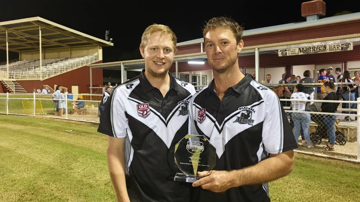 Magpies players John Hauff and captain Andrew Russell admiring the 2019 Clubbies trophy.