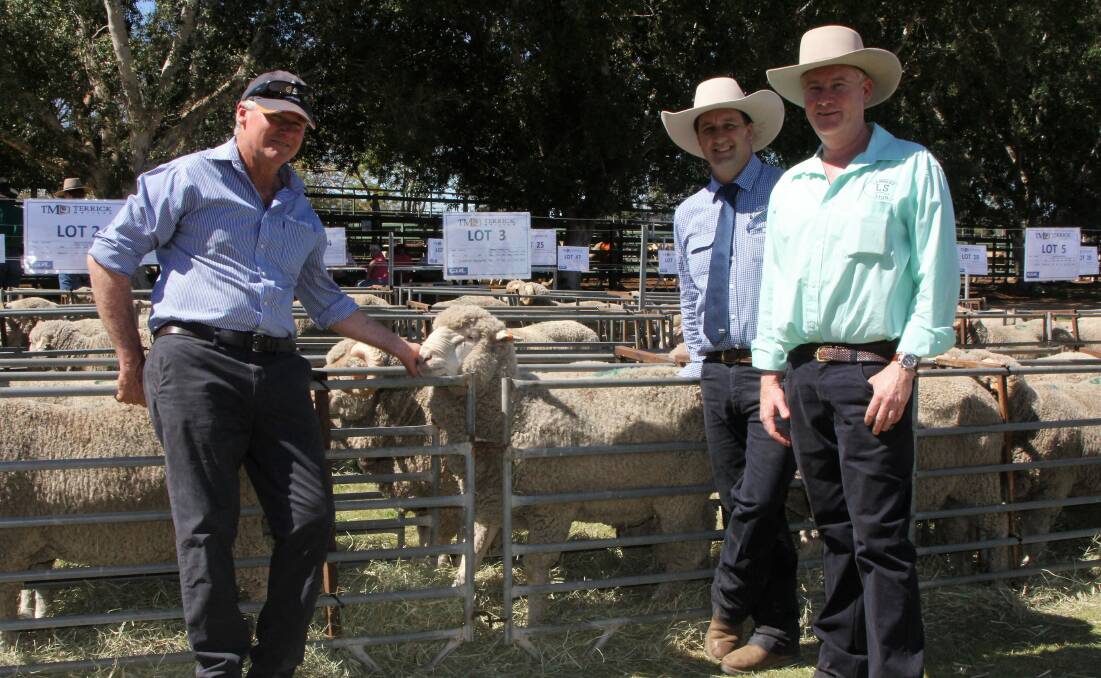 Terrick Merinos principal Rick Keogh and top priced ram of the sale, lot three, with Ben Pelizzari, GDL, and purchaser Scott Bredhauer, Lambert, Blackall. Pictures - Sally Cripps.