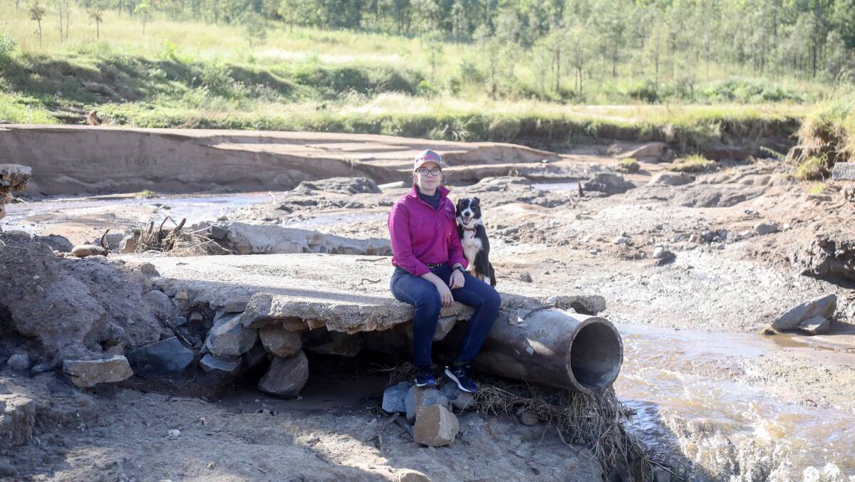 Carly Turner sits on what remains of a causeway connecting the family's property. Without it they are struggling to reach parts of their land. Picture: Lucy Kinbacher