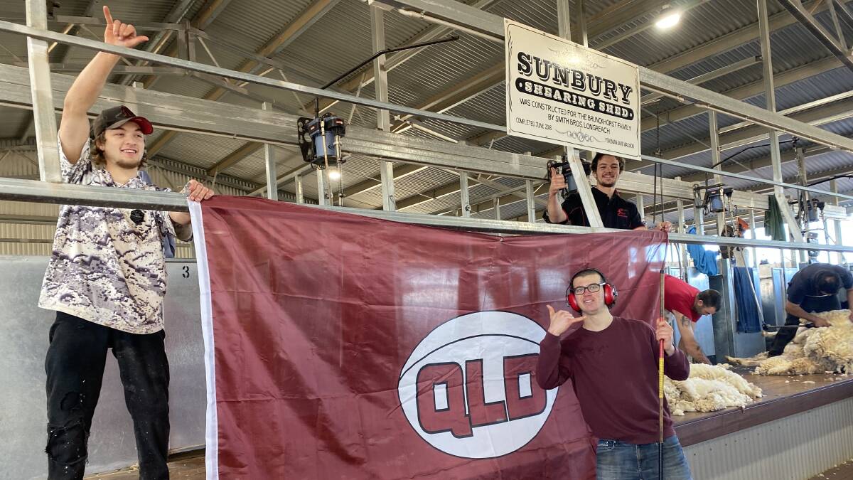Sunbury shearing team members pose for a photo around the Queensland Maroons flag. Picture: Pauline Brunkhorst