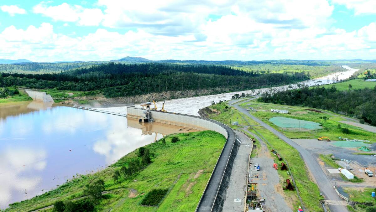 Around 20,000ML a day from the flooded Burnett River has been steadily overflowing the lowered Paradise Dam wall.
