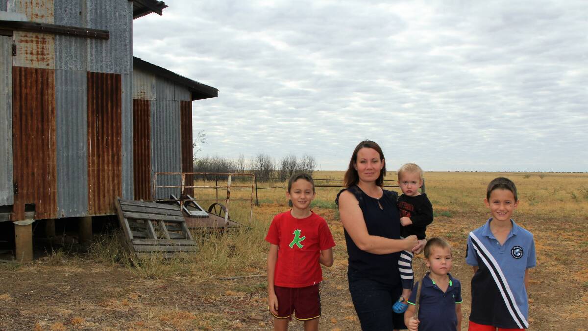 Now: The landscape behind Rachel Anderson, pictured with children Kelly, Parker, Mac and Cody, at Eddington, west of Julia Creek, was a sea of water at the height of February's flood disaster. Picture: Sally Cripps.