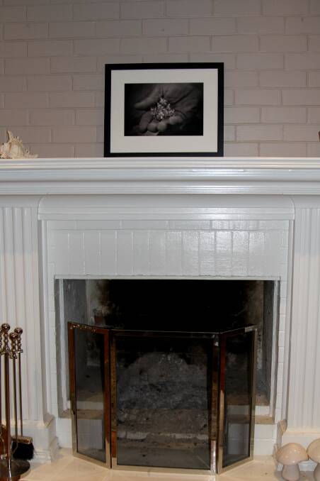 The black and white photograph above the fireplace.