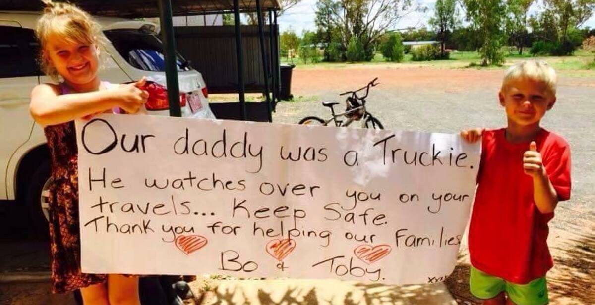 Trucking family: Bo and Toby Gattera with the sign that touched the hearts of the hay runners. Source: Facebook.