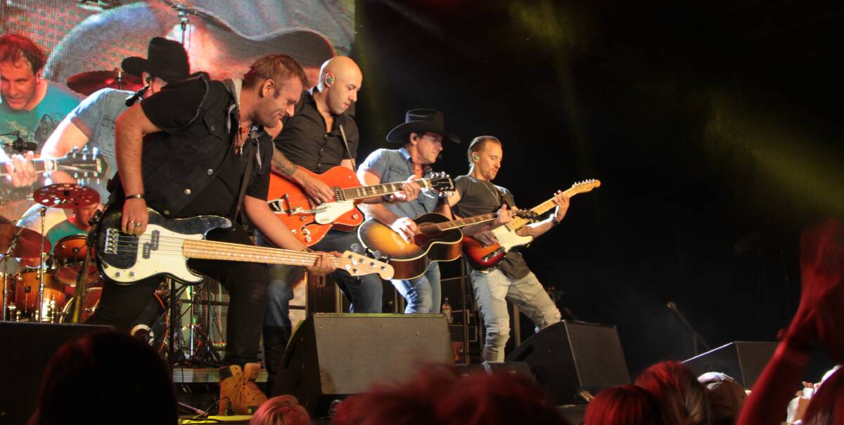 Rocking out: Lee Kernaghan and the Wolfe Brothers delivering the grand finale at the opening of the Outback Entertainment Centre in Longreach.
