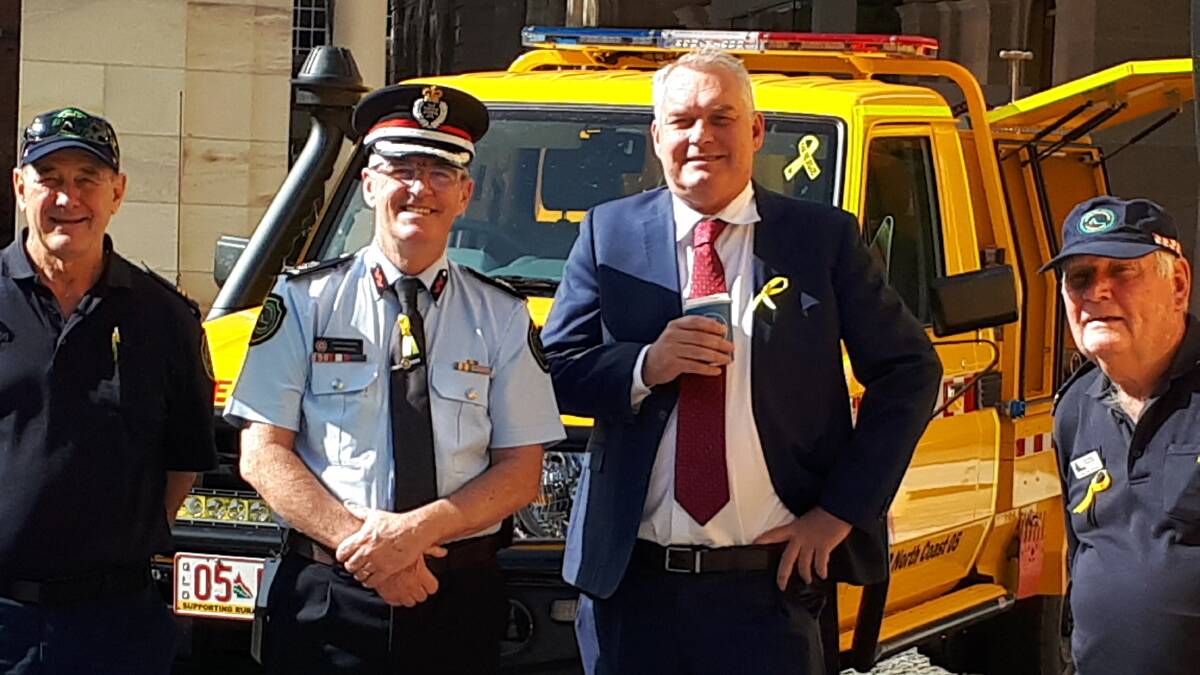 Opposition fire and emergency services minister Lachlan Millar, second right, pictured with Toorbul RFB members and Assistant Commissioner John Bolger, has called on the government to provide budget transparency.