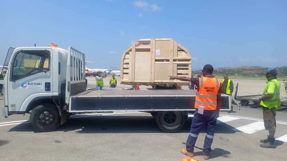 A purpose-built crate of sheep loading onto trucks at Port Moresby airport, to take them up to their new home.