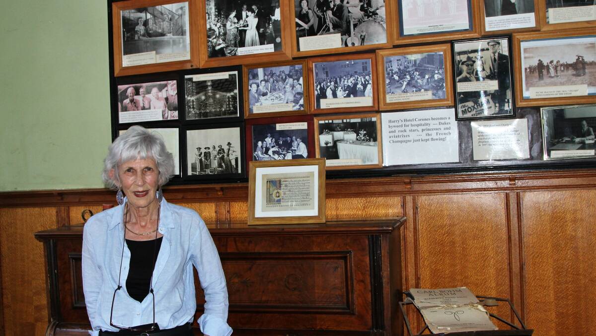 Fran Harding looks over some of the images collected of the grand history of Hotel Corones.