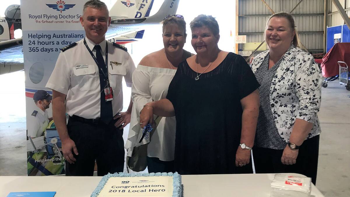 RFDS (Queensland Section) head of flying operations, Shane Lawrey, 2018 RFDS Local Hero award winners, Mande and Jackie Jäger, Pentland, and Ergon Energy Retail executive general manager, Cheryl Hopkins, cutting a celebration cake at Townsville.