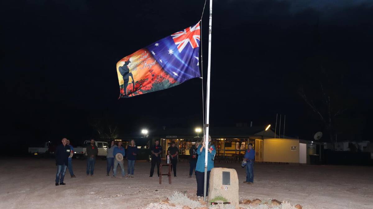 The flag being raised at Cameron Corner, on the NSW-Queensland boundary. Picture: Tina Thomas