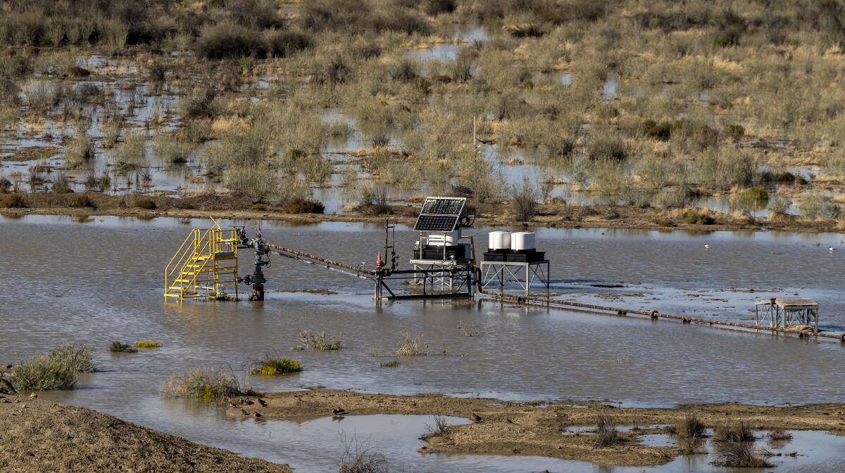 A close-up photograph of a well surrounded by floodwater in the Tirrawarra oil field in the south west Cooper Basin. Picture: Doug Gimesy