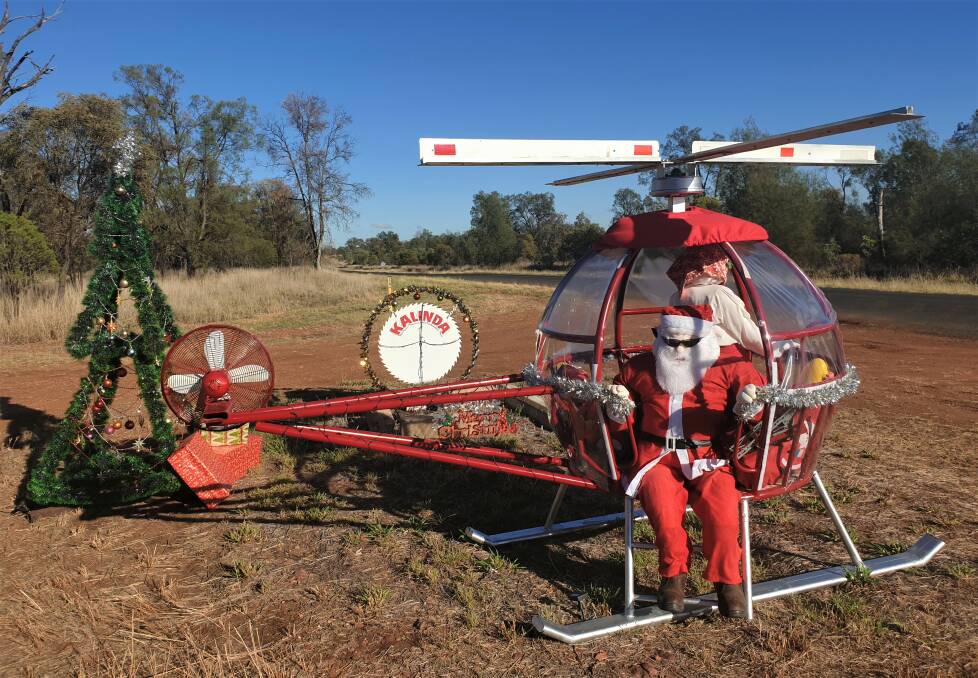 Christmas chopper: Santa prepares to alight from the helicopter crafted by Gordon Groves, Kalinda, south of Roma, while Mrs Claus holds the controls steady. Picture: Sally Gall.