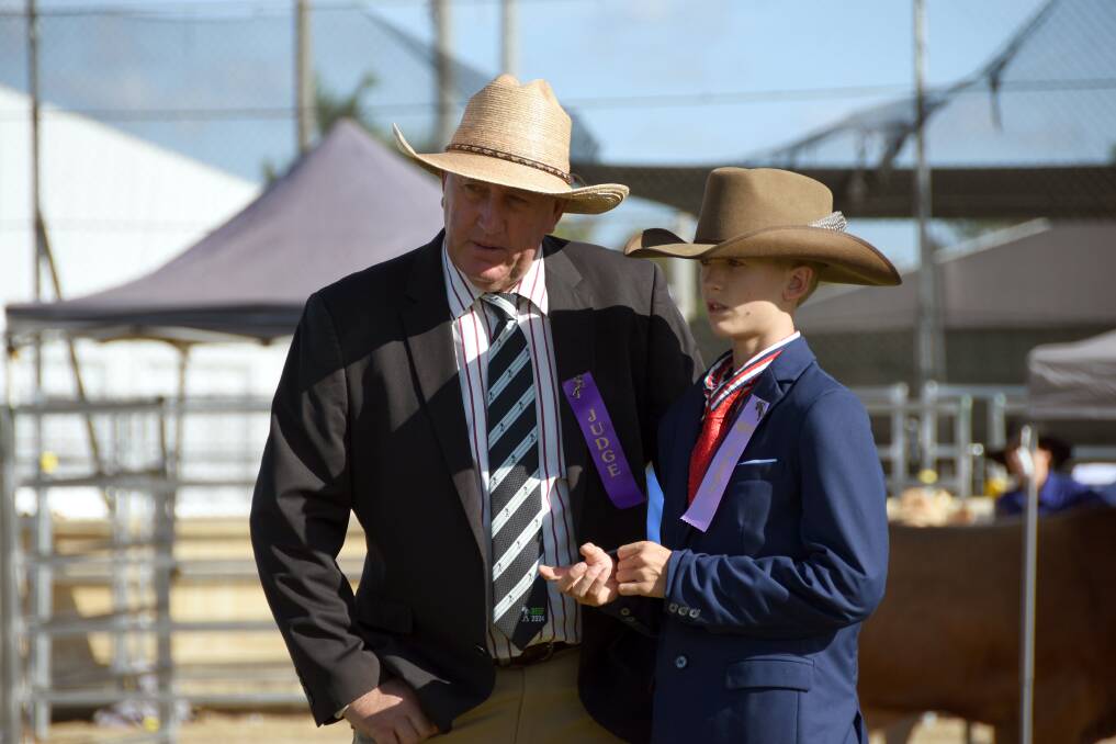Judge Scott Hann, Bellata, NSW confers with 12-year-old associate judge Callum McUtchen, Jandowae at the Blonde d'Aquitaine competition. Picture by Ashley Walmsley