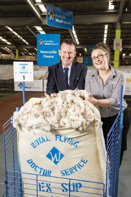 Brett Cooper from Australian Wool Network (NSW) shows Prue Steel from the Royal Flying Doctors Service the bales of Merino wool up for auction to raise vital funds for the RFDS during their 90th anniversary year.