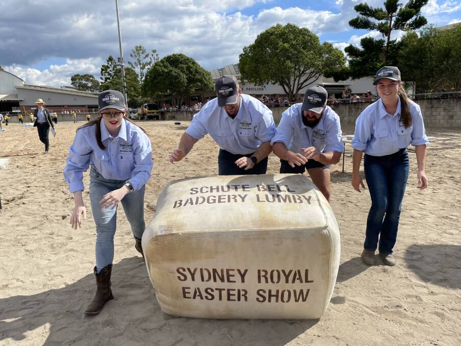 The NSW team of Madelyn Hayes and Zac Ruddock from Albion Park; Tom Wilson from Jambaroo and Kara Edwards from Marshal Mount rolling their bale of wool to the finish line of the national Young Farmers Challenge at Sydney Royal Show.