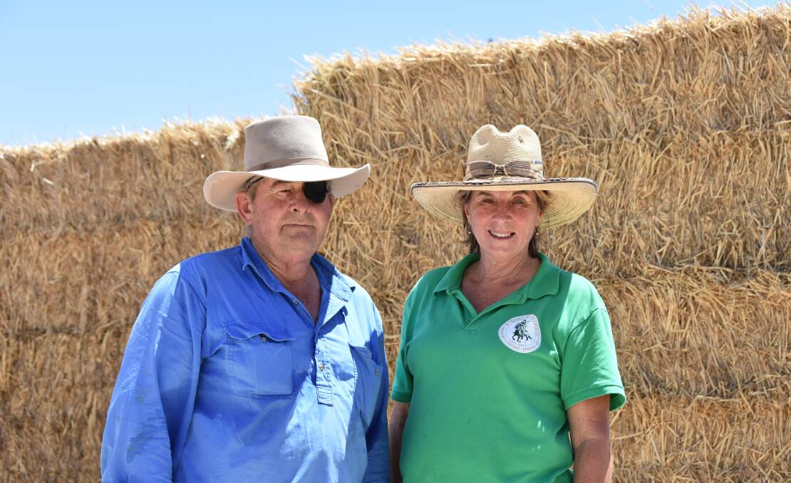 Beef producers Jeff and Debbie Nichols with Rural Aid hay bales at a collection point in Winton. 