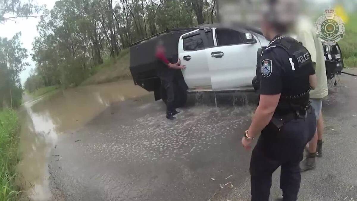 A 23-year-old man has been fined by police for driving through floodwaters in Central Queensland, after he and his dog became trapped. Photo: Police 